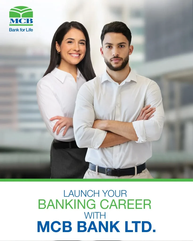 Pakistani bank cashier helping customers while trainee employees observe banking work inside a modern bank branch.